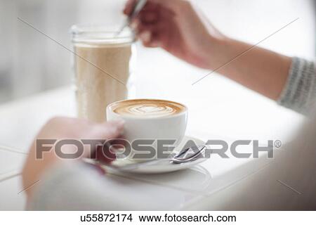Picture - Woman in cafe with coffee cup, close up. Fotosearch