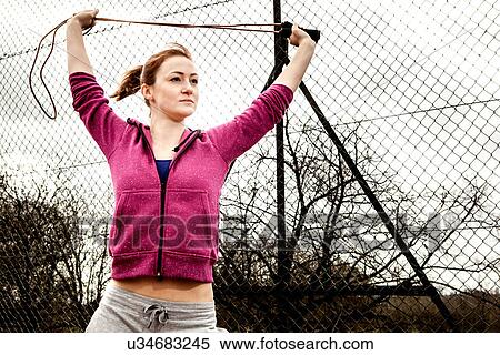 Woman in hoodie stretching pilates rope above head View Large Photo Image Stock Photography - Woman in hoodie stretching pilates rope above head. Fotosearch