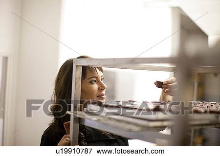 Stock Photo - Woman inspecting chocolate in commercial kitchen. Fotosearch