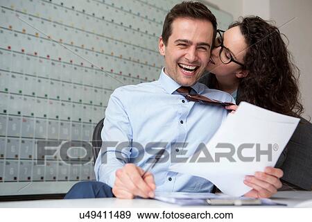 Woman kissing businessman's ear View Large Photo Image Stock Photo - Woman kissing businessman's ear. Fotosearch