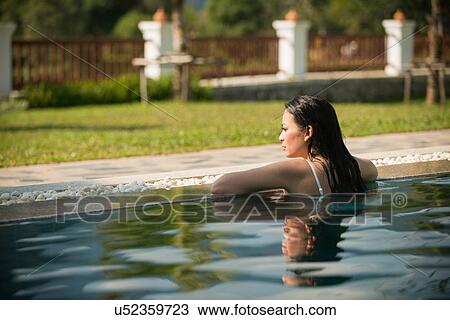Woman leaning on edge of swimming pool View Large Photo Image Stock Image - Woman leaning on edge of swimming pool. Fotosearch
