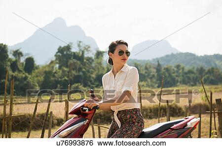 Woman on moped, Vang Vieng, Laos View Large Photo Image Stock Photograph - Woman on moped, Vang Vieng, Laos. Fotosearch