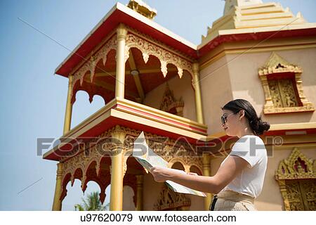 Stock Photo - Woman outside building with map, Luang Prabang, Laos. Fotosearch