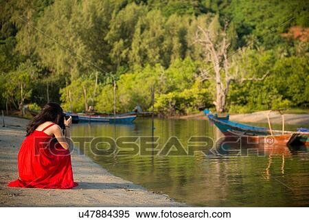 Stock Photography - Woman photographing boats, Taling Ngam Beach, Ko Samui, Thailand. Fotosearch