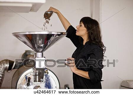 Woman pouring cocoa beans into funnel View Large Photo Image Stock Photo - Woman pouring cocoa beans into funnel. Fotosearch