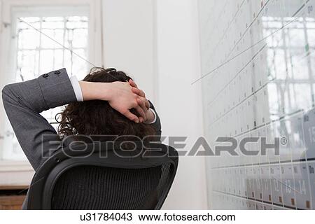 Woman sitting in office chair in front of large wall calendar View Large Photo Image Stock Image - Woman sitting in office chair in front of large wall calendar. Fotosearch