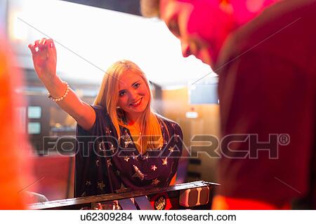 Picture - Woman standing in front of disc jockey's mixing desk. Fotosearch