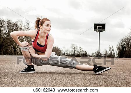 Woman stretching left leg and bending right leg on court View Large Photo Image Stock Image - Woman stretching left leg and bending right leg on court. Fotosearch