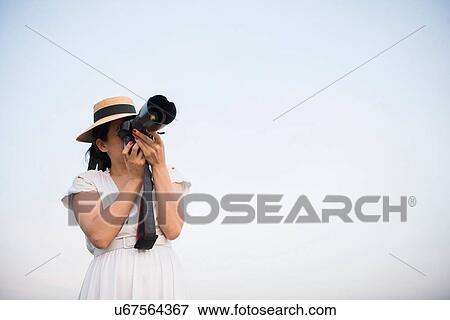 Woman taking photograph against clear sky View Large Photo Image Stock Photo - Woman taking photograph against clear sky. Fotosearch