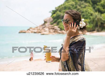 Woman using mobile phone on beach, Banyon Tree Resort, Ko Samui, Thailand View Large Photo Image Stock Photograph - Woman using mobile phone on beach, Banyon Tree Resort, Ko Samui, Thailand. Fotosearch