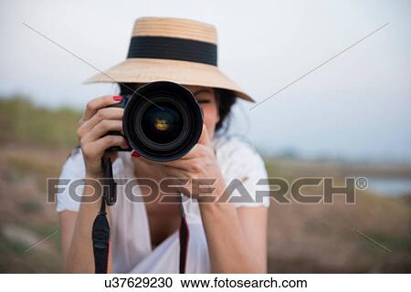 Woman wearing hat taking photograph View Large Photo Image Stock Image - Woman wearing hat taking photograph. Fotosearch