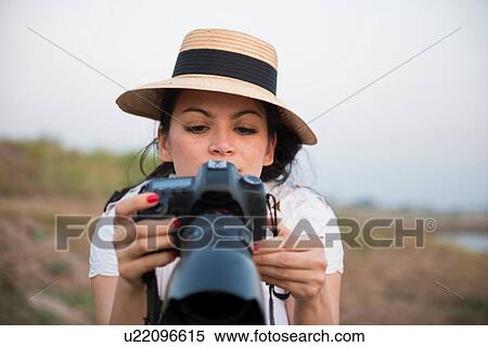 Woman wearing hat taking photograph View Large Photo Image Stock Photography - Woman wearing hat taking photograph. Fotosearch