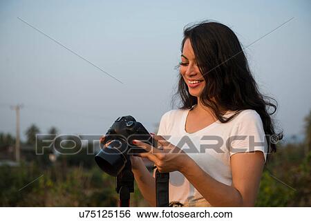 Woman with long black hair holding camera View Large Photo Image Stock Photograph - Woman with long black hair holding camera. Fotosearch