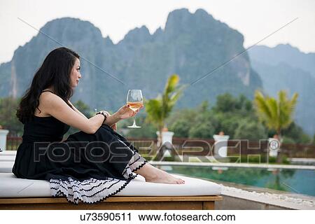 Woman with wine glass by poolside, Vang Vieng, Laos View Large Photo Image Stock Image - Woman with wine glass by poolside, Vang Vieng, Laos. Fotosearch