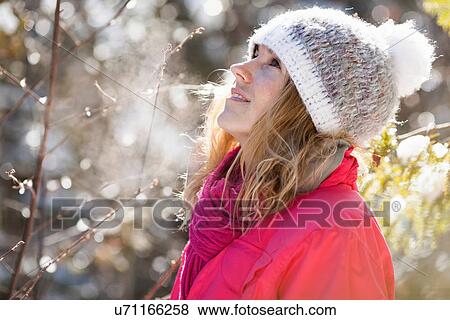 Young adult woman among snow-covered tree branches View Large Photo Image Stock Photo - Young adult woman among snow-covered tree branches. Fotosearch