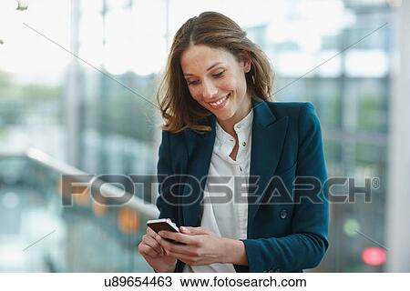 Young business woman outside office buildings using smartphone View Large Photo Image Stock Image - Young business woman outside office buildings using smartphone. Fotosearch