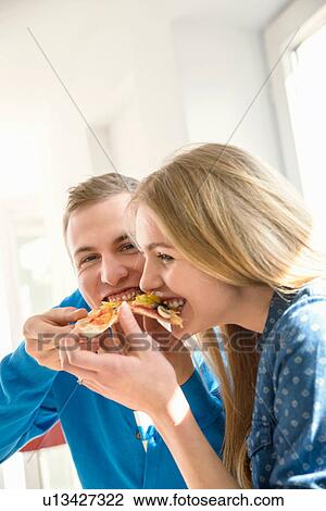 Young couple eating pizza View Large Photo Image Stock Image - Young couple eating pizza. Fotosearch