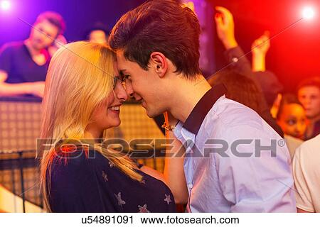 Young couple face to face at party, group behind View Large Photo Image Stock Image - Young couple face to face at party, group behind. Fotosearch