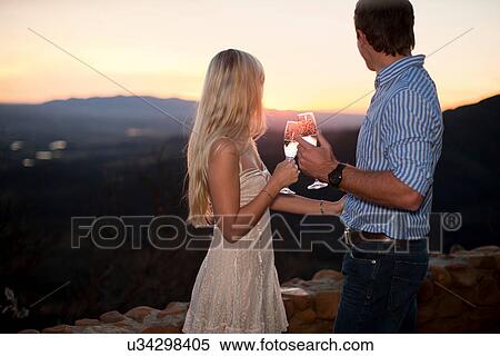 Young couple having champagne outdoors at sunset View Large Photo Image Stock Photography - Young couple having champagne outdoors at sunset. Fotosearch