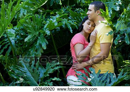 Young couple hugging in plants View Large Photo Image Stock Image - Young couple hugging in plants. Fotosearch