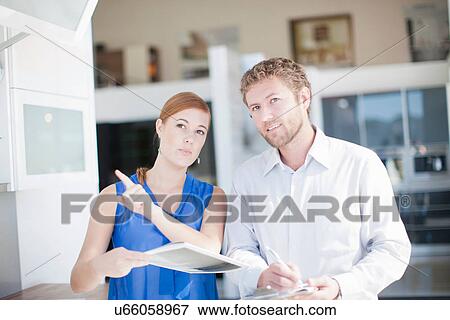 Young couple in kitchen showroom View Large Photo Image Stock Photo - Young couple in kitchen showroom. Fotosearch
