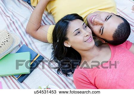 Young couple lying on picnic blanket View Large Photo Image Stock Image - Young couple lying on picnic blanket. Fotosearch
