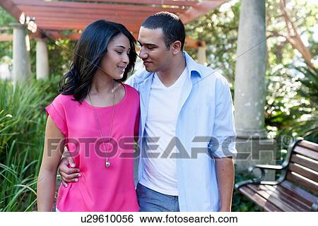 Stock Photograph - Young couple, man with arm around woman. Fotosearch
