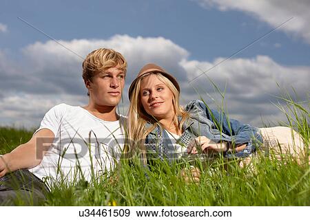 Young couple relaxing on grass View Large Photo Image Stock Photo - Young couple relaxing on grass. Fotosearch
