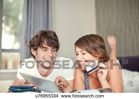 Picture - Young couple with digital tablet and credit card. Fotosearch