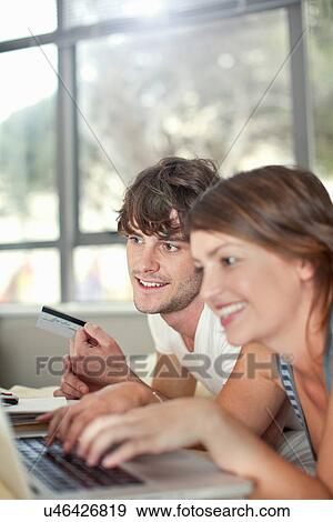 Young couple with laptop and credit card View Large Photo Image Stock Photo - Young couple with laptop and credit card. Fotosearch