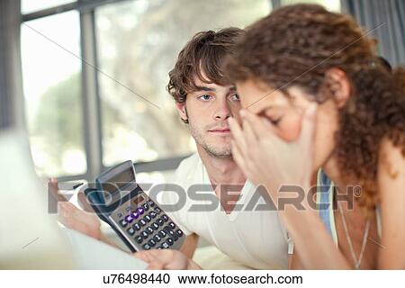 Stock Image - Young couple worrying over finances. Fotosearch