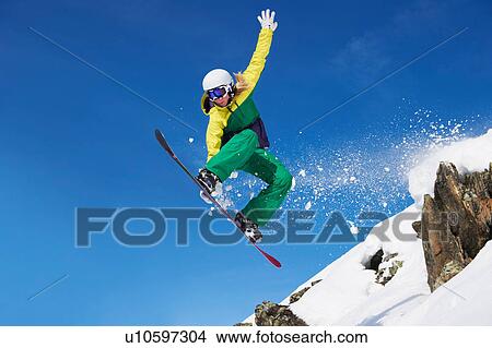 Picture - Young female snowboarder jumping. Fotosearch