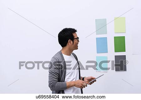 Young male designer looking at color swatch View Large Photo Image Picture - Young male designer looking at color swatch. Fotosearch
