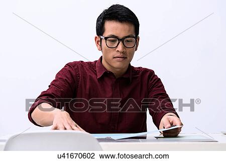 Young male designer looking at samples on desk View Large Photo Image Stock Image - Young male designer looking at samples on desk. Fotosearch