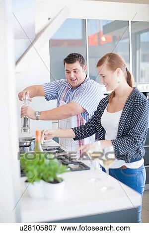 Stock Photo - Young man and woman cooking in kitchen. Fotosearch