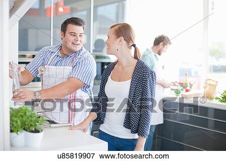Young man and woman cooking in kitchen View Large Photo Image Stock Photo - Young man and woman cooking in kitchen. Fotosearch