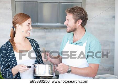 Young man and woman cooking in kitchen View Large Photo Image Stock Photograph - Young man and woman cooking in kitchen. Fotosearch