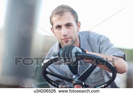 Stock Photograph - Young man at wheel of vehicle. Fotosearch