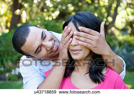 Young man covering woman's eye View Large Photo Image Stock Photo - Young man covering woman's eye. Fotosearch