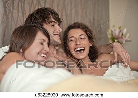 Young man in bed with two young women View Large Photo Image Stock Image - Young man in bed with two young women. Fotosearch