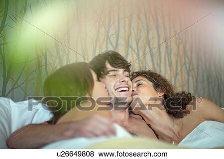 Young man in bed with two young women View Large Photo Image Stock Photo - Young man in bed with two young women. Fotosearch