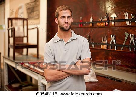 Stock Photograph - Young man in furniture workshop. Fotosearch
