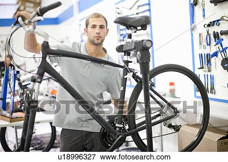 Young man in repair shop with bicycle View Large Photo Image Stock Photo - Young man in repair shop with bicycle. Fotosearch