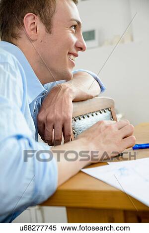 Stock Photography - Young man leaning on chair. Fotosearch