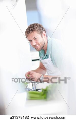 Young man preparing food View Large Photo Image Stock Image - Young man preparing food. Fotosearch