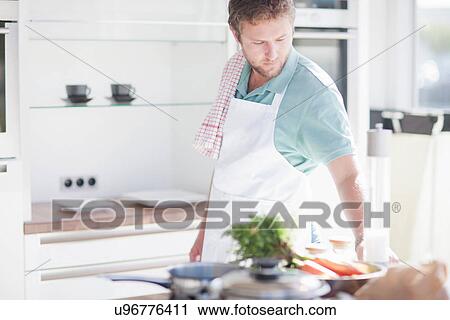 Young man preparing meal in kitchen View Large Photo Image Stock Image - Young man preparing meal in kitchen. Fotosearch