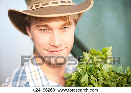 Young man with vegetables grown on farm View Large Photo Image Stock Image - Young man with vegetables grown on farm. Fotosearch