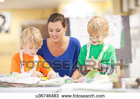 Young woman and boys in art class View Large Photo Image Stock Image - Young woman and boys in art class. Fotosearch