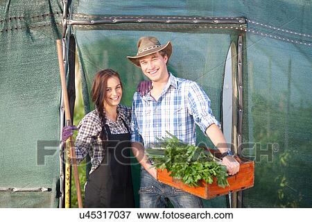 Young woman and man with vegetables grown on farm View Large Photo Image Stock Photo - Young woman and man with vegetables grown on farm. Fotosearch