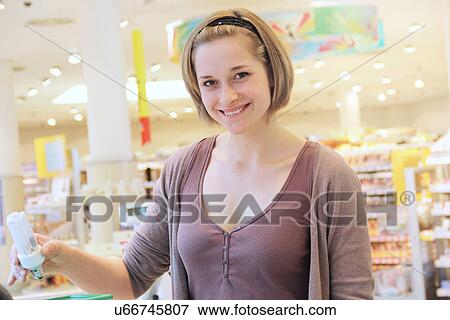 Young woman buying energy saving lightbulb from supermarket View Large Photo Image Stock Photo - Young woman buying energy saving lightbulb from supermarket. Fotosearch